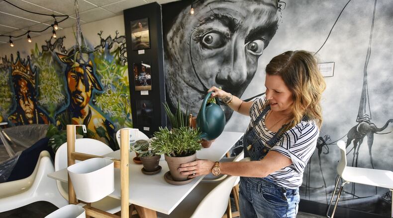 Sarah Davis waters plants at The Fringe Coffee House, which will employ felons and have a variety of musical performances and artistic murals, expects to open this fall. NICK GRAHAM/STAFF