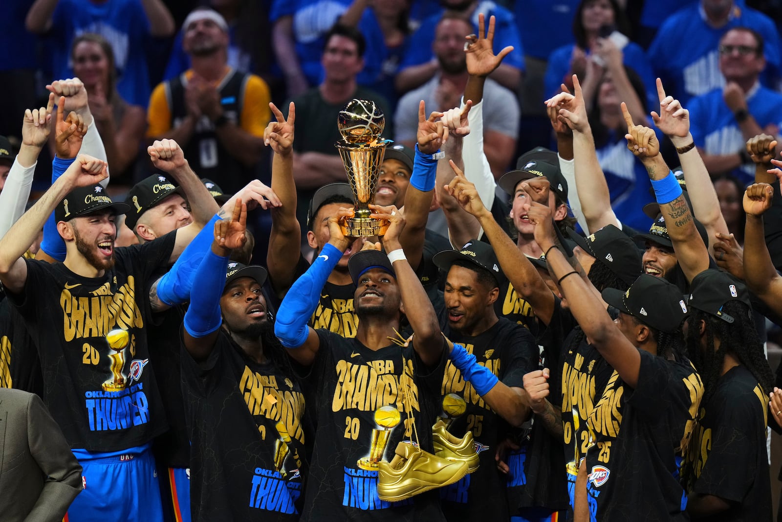Oklahoma City Thunder guard Shai Gilgeous-Alexander, center, holds up the MVP trophy as he celebrates with his team after they won the NBA basketball championship with a Game 7 victory against the Indiana Pacers Sunday, June 22, 2025, in Oklahoma City. (AP Photo/Nate Billings)