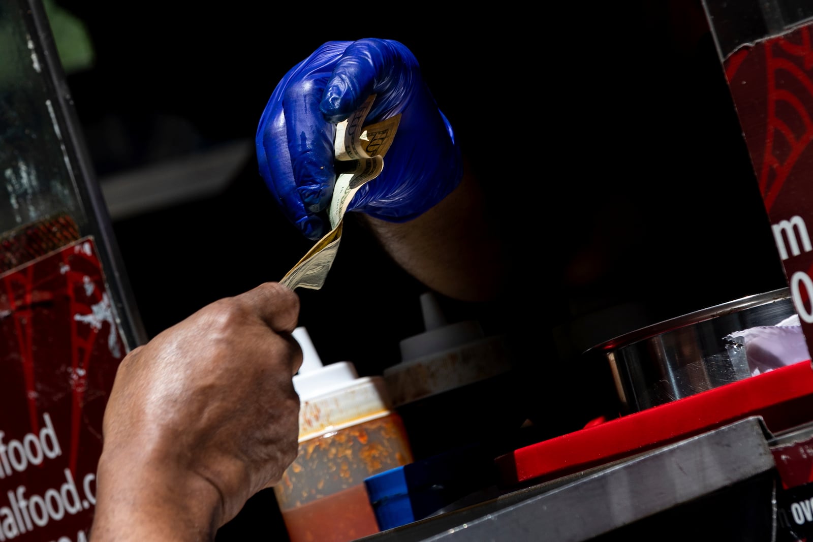 FILE - A person pays with cash at a Halal food truck, July 13, 2022, in New York. (AP Photo/Julia Nikhinson, file)