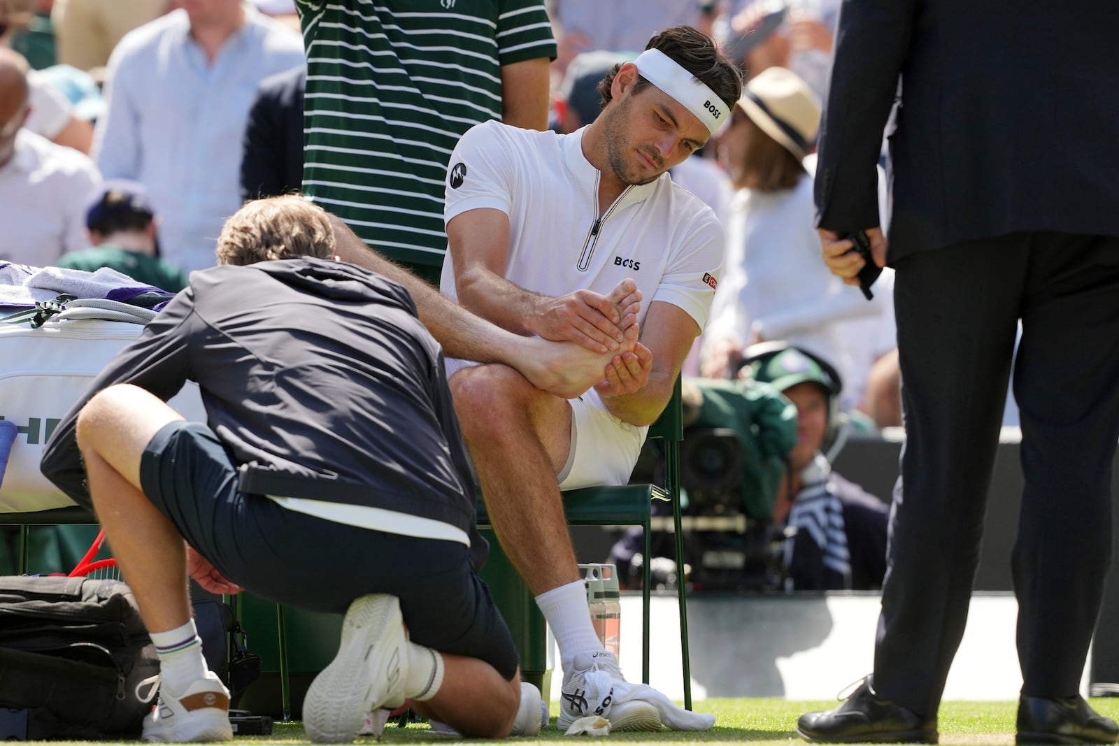 Taylor Fritz of the U.S. gets medical assistance during the men's singles quarter final match against Karen Khachanov of Russia at the Wimbledon Tennis Championships in London, Tuesday, July 8, 2025.(AP Photo/Kin Cheung)