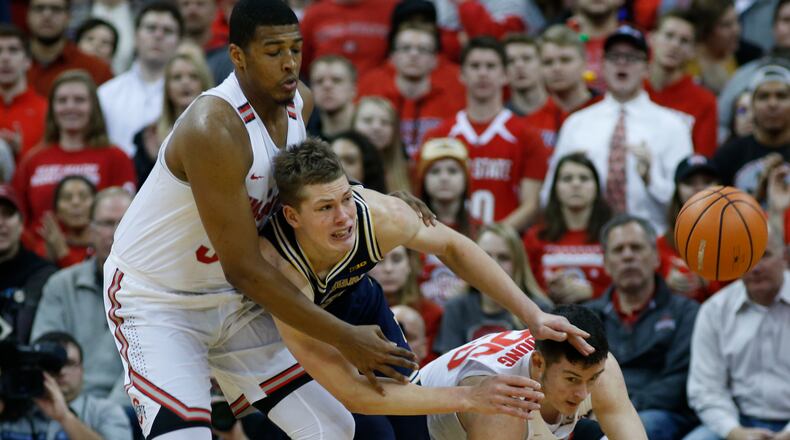 Michigan’s Moritz Wagner, center, passes the ball as Ohio State’s Kaleb Wesson, left, and Kyle Young defend during the first half of an NCAA college basketball game Monday, Dec. 4, 2017, in Columbus, Ohio. (AP Photo/Jay LaPrete)