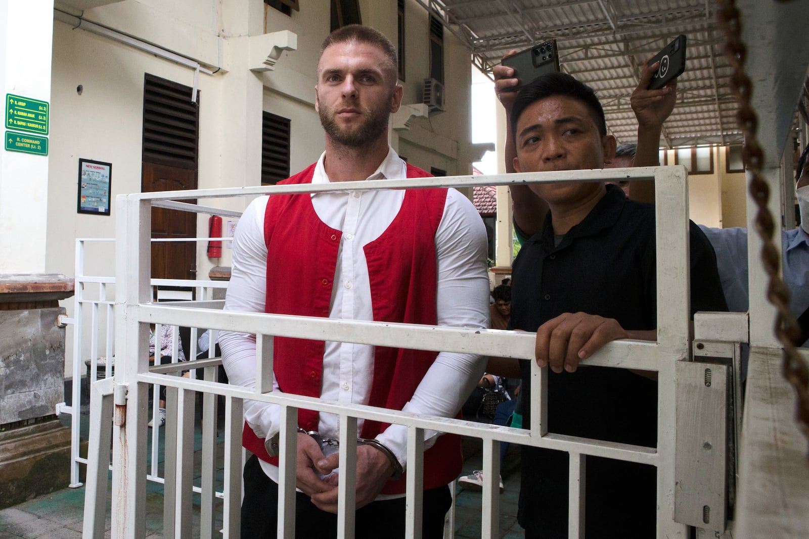 British citizen Thomas Parker, left, walks to a holding cell after he is sentenced for drug offenses, in Denpasar in Bali, Indonesia, Tuesday, May 27, 2025. (AP Photo/Firdia Lisnawati)