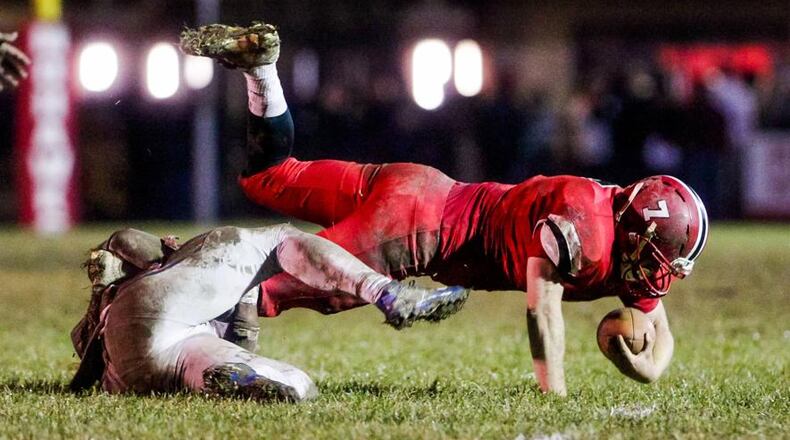 Madison quarterback Mason Whiteman fights for every extra yard Saturday night during the Mohawks’ 26-0 victory over Portsmouth in a Division V, Region 20 playoff game at Brandenburg Field in Madison Township. NICK GRAHAM/STAFF