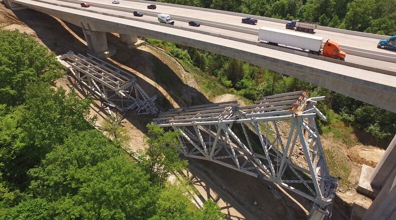 The third time was not quite the charm that ODOT officials were expecting as contractors tried again to take down the remaining steel structure of the Jeremiah-Morrow Bridge last weekend. For the third day, I-71 was shut down on a Sunday morning to allow explosive demolition work to be performed next to new concrete bridges that carry traffic over the Little Miami River Valley in Warren County. One stubborn steel expanse on the north side of the old bridge failed to collapse in the last round of explosive charges, leaving large pieces of the structure intact and still attached to the concrete piers. Chunks of steel structure from the south side of the bridge are being trucked away daily. TY GREENLEES / STAFF