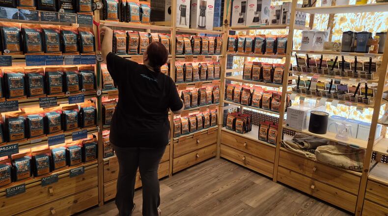 A clerk works with displays at Poppets Coffee and Tea's 2nd Street Market location. Poppets is opening a new location Oct. 13 in spite of tariff uncertainty. Michael Kurtz / Staff