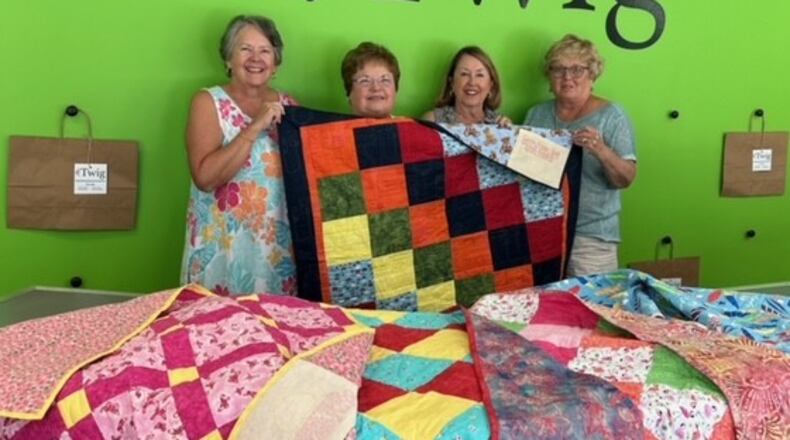 Carole Chizik, Julie Baker, Debbie Goldshot and Peggy Freeman show off quilts that will be donated to The Twig, an organization that supports children in foster care. CONTRIBUTED