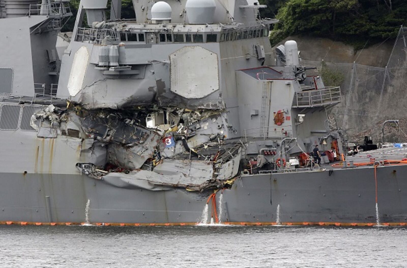 Damaged part of USS Fitzgerald is seen at the U.S. Naval base in Yokosuka, southwest of Tokyo Sunday, June 18, 2017. Navy divers found seven sailors' bodies Sunday aboard the stricken USS Fitzgerald that collided with a container ship in the busy sea off Japan (AP Photo/Eugene Hoshiko)