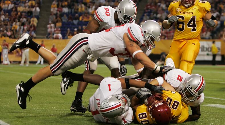 MINNEAPOLIS, MN - SEPTEMBER 29:  James Laurinaitis #33 of the Ohio State Buckeyes jumps to assist his teammates Marcus Freeman #1 and Malcolm Jenkins #2 to tackle Jack Simmons #80  of the Minnesota Golden Gophers in the third quarter at the Metrodome on September 29, 2007 in Minneapolis, Minnesota.  Ohio State defeated Minnesota 30- 7.  (Photo by Jeff Gross/Getty Images)    2