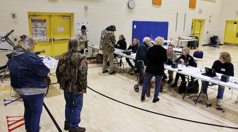Poll workers check in voters on election day Tuesday, March 19, 2024 at Highland Elementary School in Hamilton. NICK GRAHAM/STAFF