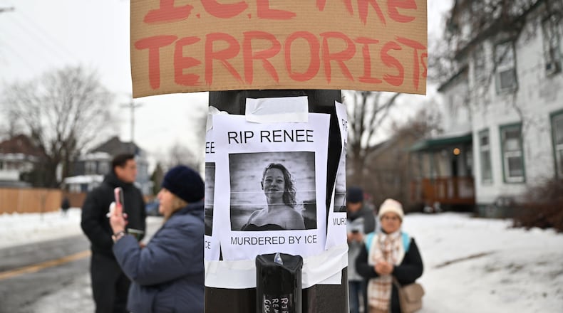 People gather around a makeshift memorial honoring the victim of a fatal shooting involving federal law enforcement agents, near the site of the shooting, Thursday, Jan. 8, 2026, in Minneapolis. (AP Photo/Tom Baker)