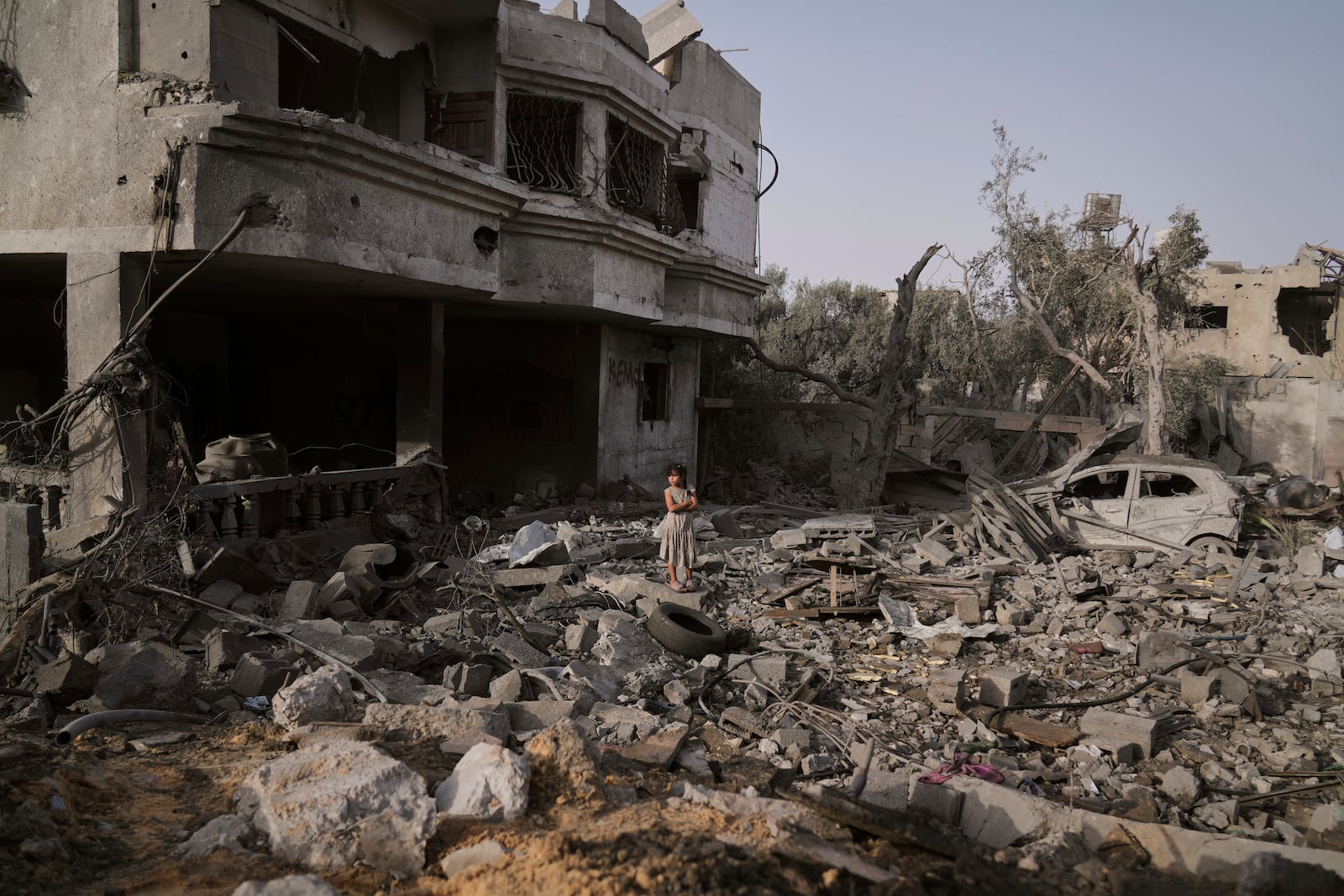 A Palestinian girl stands atop the rubble of the Al-Aimawi family's home, destroyed by Israeli airstrikes in Al-Zawaideh, Gaza Strip, on Tuesday, July 1, 2025. (AP Photo/Abdel Kareem Hana)