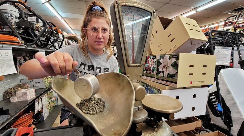 Sophie Grollmus weighs seeds Friday, June 18, 2021 on a 99-year-old scale used by her great grandfather Al Huesman, who started Al Joe's Pet and Garden Center.
Al-Joe's Pet and Garden Centers are celebrating 100 years in business this year. They now have locations in Hamilton and West Chester Township. NICK GRAHAM / STAFF