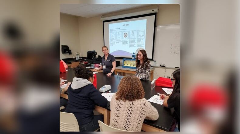 Miami University CiQS (Careers Involving Quantitative Skills) Day included female professors and professionals from Southwest Ohio making presentations and interacting with Butler County high school girls exploring possible careers in STEM (science, technology, engineering and mathematics) industries. Pictured are Miami professors demonstrating treatments to reduce turbidity in Ohio River water samples as part of the water purification process.(Provided Photo/Journal-News)