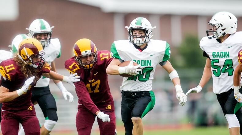 Badin’s Alex DeLong (20) is escorted by teammate Evan Schlensker (54) as Jordan Hodge (11) and Sean Lange (17) of Ross are in pursuit during an Aug. 24 game at Robinson Field in Ross Township. Badin won 41-20. NICK GRAHAM/STAFF
