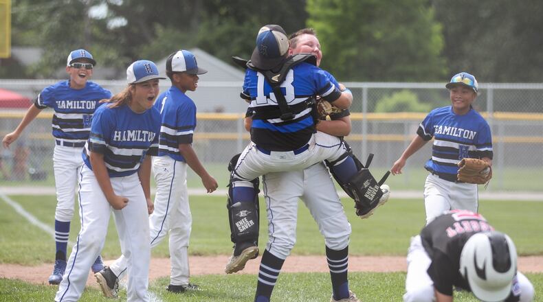 Hamilton West Side’s Blake Detherage (13) jumps into the arms of teammate Casey Parsons after Parsons tagged Canfield’s Connor Daggett (5) for the final out Thursday in the winners’ bracket final of the Ohio Little League 12-year-old baseball tournament at Ford Park in Maumee. CONTRIBUTED PHOTO BY SCOTT GRAU