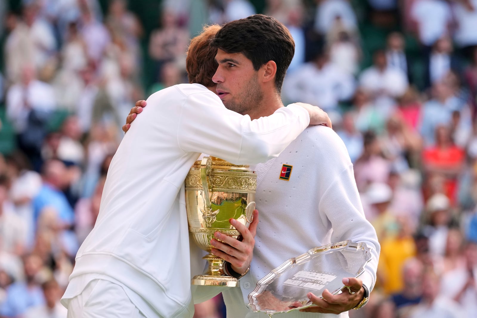 Jannik Sinner of Italy hugs Carlos Alcaraz of Spain after winning the men's singles final match at the Wimbledon Tennis Championships in London, Sunday, July 13, 2025.(AP Photo/Kirsty Wigglesworth)