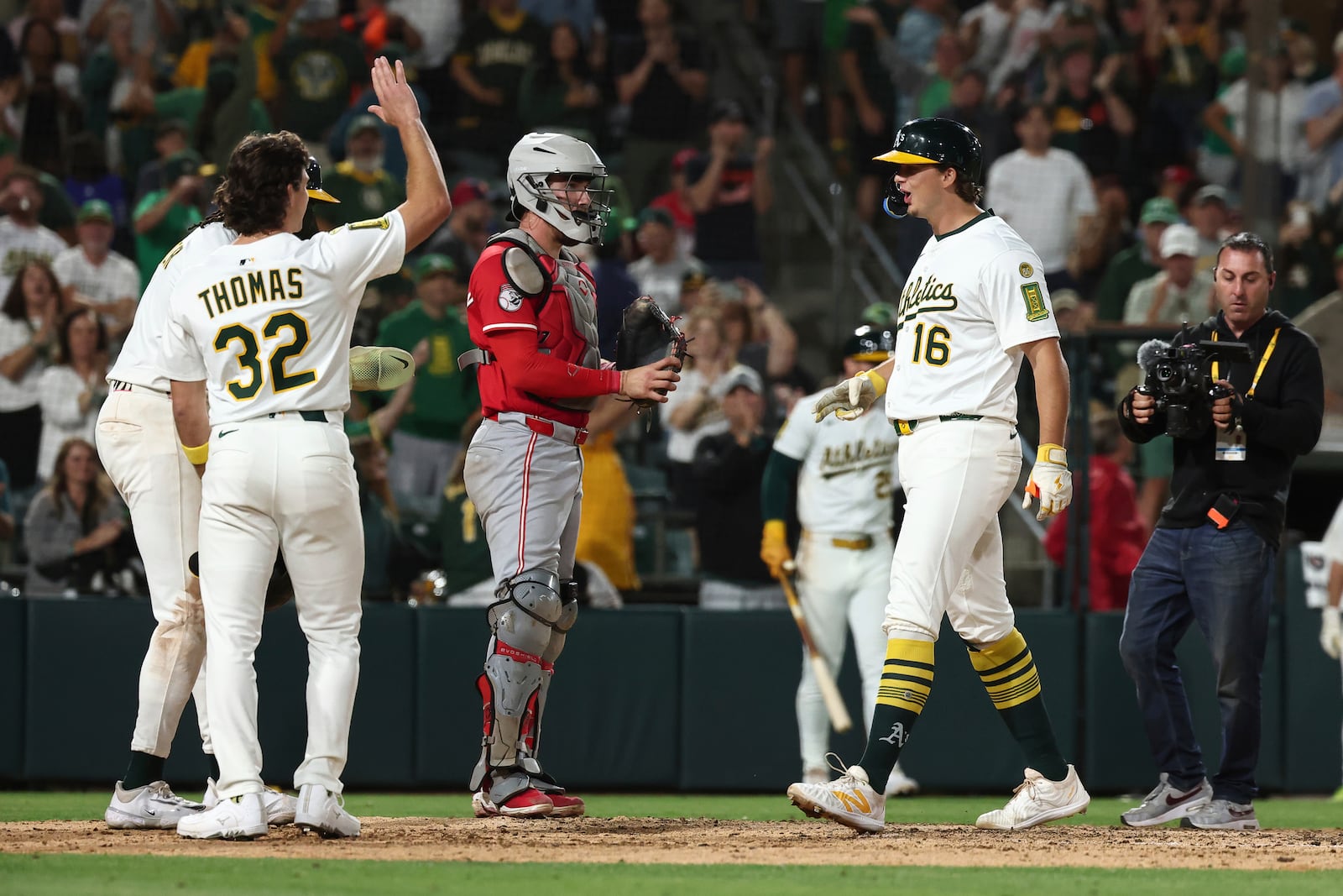 Athletics' Nick Kurtz, right, celebrates as he crosses home plate after hitting a grand slam during the eighth inning of a baseball game against the Cincinnati Reds Saturday, Sept. 13, 2025, in West Sacramento, Calif. (AP Photo/Sara Nevis)