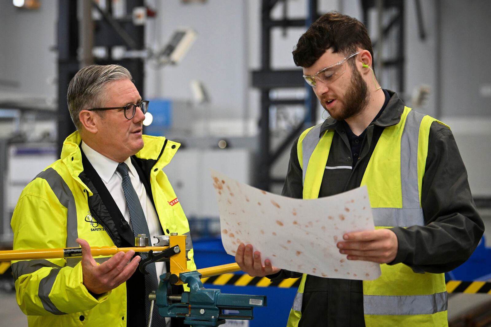 Britain's Prime Minister Keir Starmer, left, speaks to a member of staff during a visit to the BAE Systems'Govan facility, in Glasgow, Scotland, Monday June 2, 2025. (Andy Buchanan, Pool Photo via AP)
