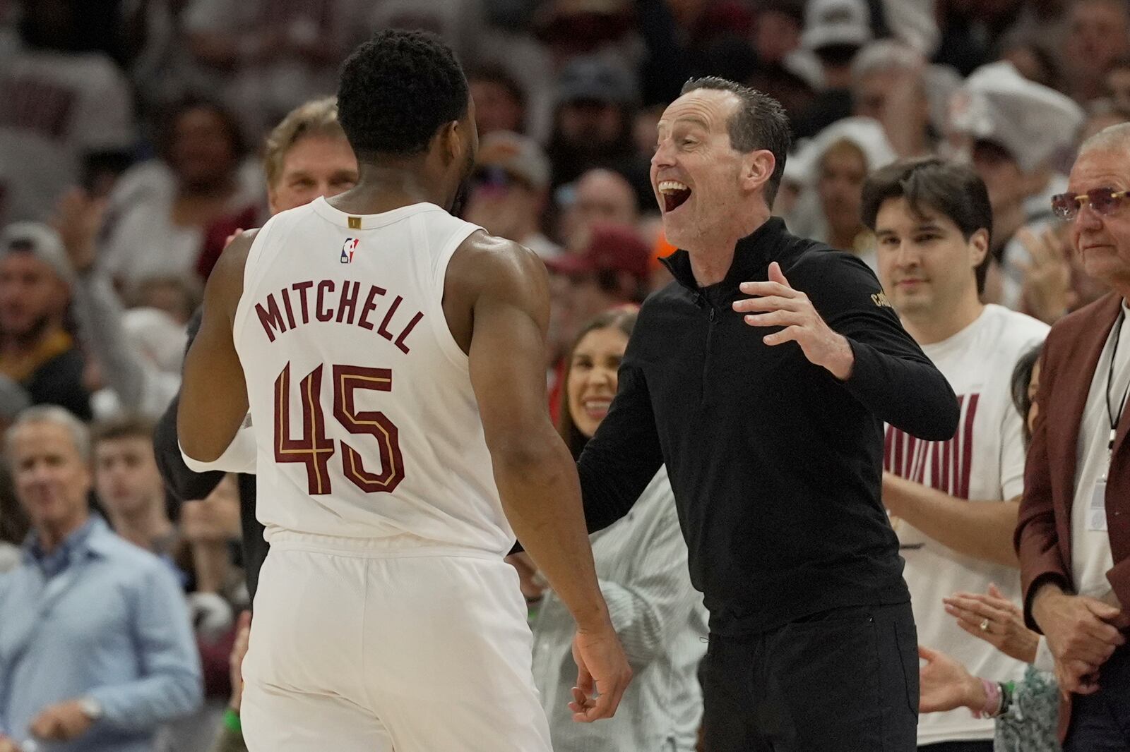 Cleveland Cavaliers head coach Kenny Atkinson, right, greets guard Donovan Mitchell (45) as he returns to the bench late in the second half in Game 1 of an NBA first-round playoff series against the Miami Heat, Sunday, April 20, 2025, in Cleveland. (AP Photo/Sue Ogrocki)