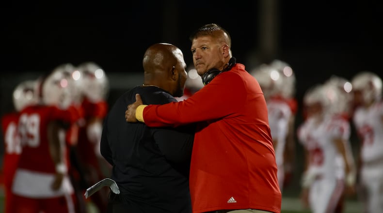 Wayne coach Roosevelt Mukes, left, and Fairfield coach Jason Krause hug after the game on Friday, Aug.18, 2023, at Heidkamp Stadium in Huber Heights. David Jablonski/Staff