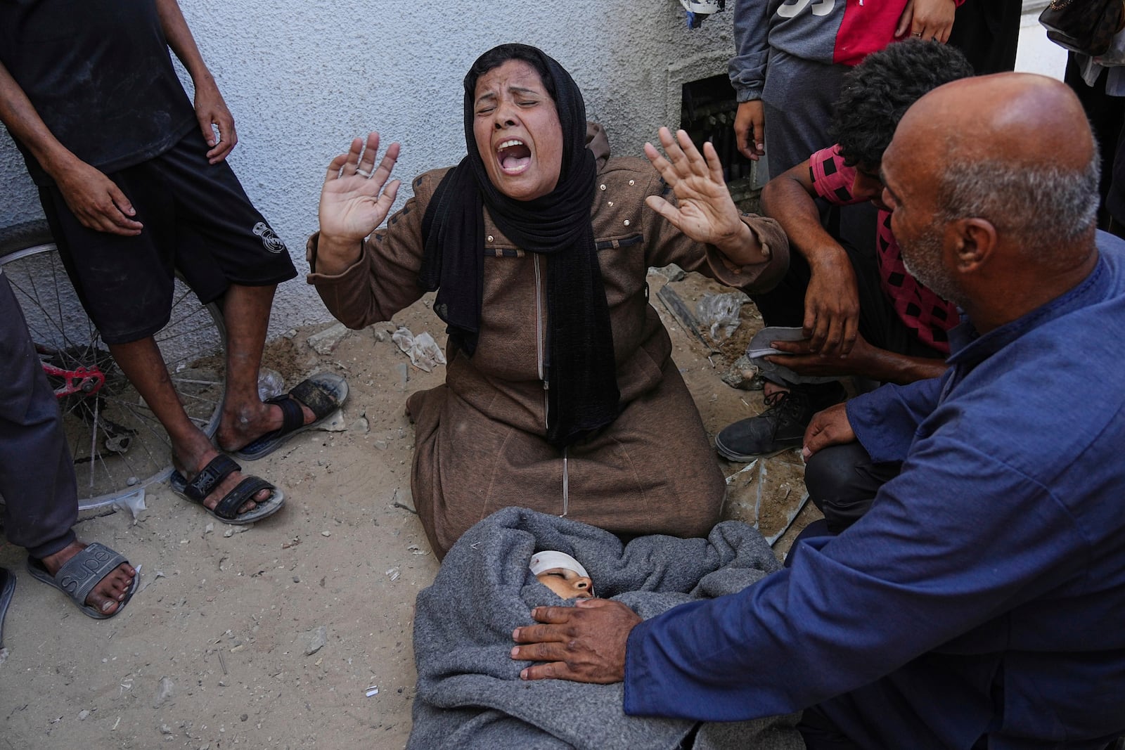 A Palestinian woman mourns over the body of her child killed in an Israeli military strike on Gaza, at Al-Shifa Hospital in Gaza City, Thursday, June 19, 2025. (AP Photo/Jehad Alshrafi)