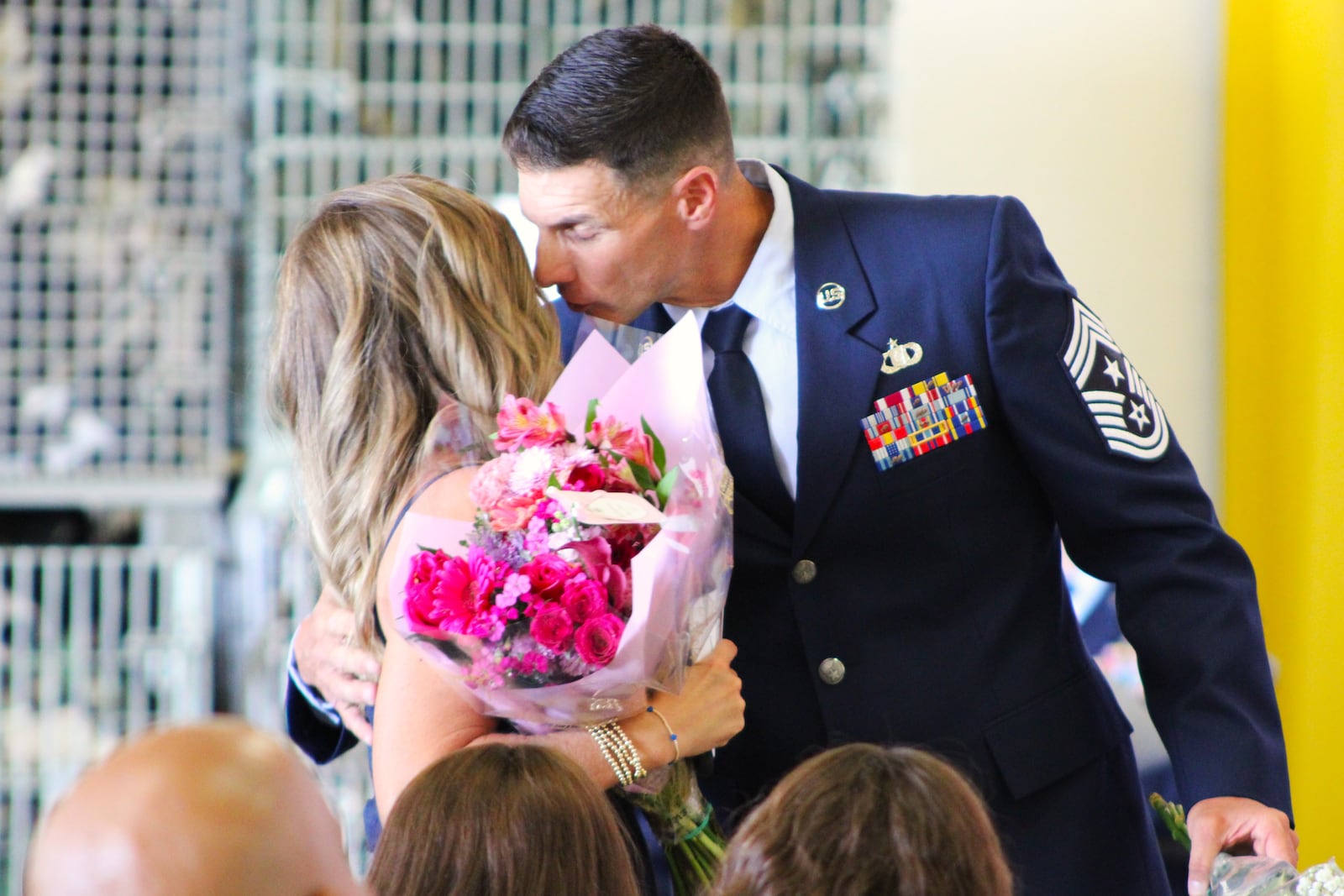 Air National Guard 178th Wing Command Chief Charles Hansel greets his wife and daughters with flower bouquets during his speech at a ceremony at the Springfield-Beckley Air National Guard Base on Saturday, Sept. 6, 2025. STAFF/SYDNEY DAWES