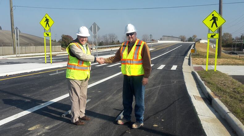 Warren County Engineer Neil Tunison shakes hands with Project Inspector Jeff Jones at the completed Socialville-Fosters Bridge over Interstate 71. CONTRIBUTED