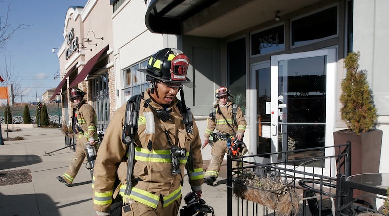 Firefighters respond to a fire in the kitchen of Cena restaurant near the Dayton Mall Saturday, Dec. 26. Customers and employees at adjacent businesses were evacuated during the fire.