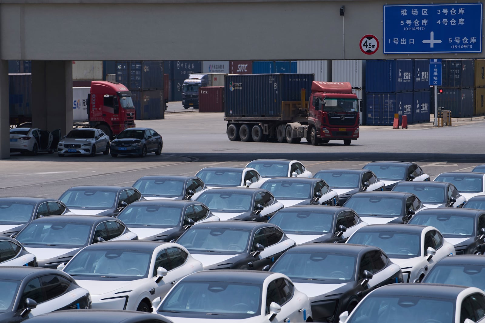 A truck moves by Changan's Avatr car models waiting for shipment at a logistics center near the Chongqing Railway Container Terminal Station, in southwest China's Chongqing Municipality on Tuesday, May 20, 2025. (AP Photo/Andy Wong)