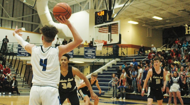 Lakota East’s Nate Johnson (34) keeps a close eye on Hamilton’s Jaylen Robinson (4) during Tuesday night’s game at the Hamilton Athletic Center. Visiting East won 47-40 to capture the outright Greater Miami Conference championship. RICK CASSANO/STAFF