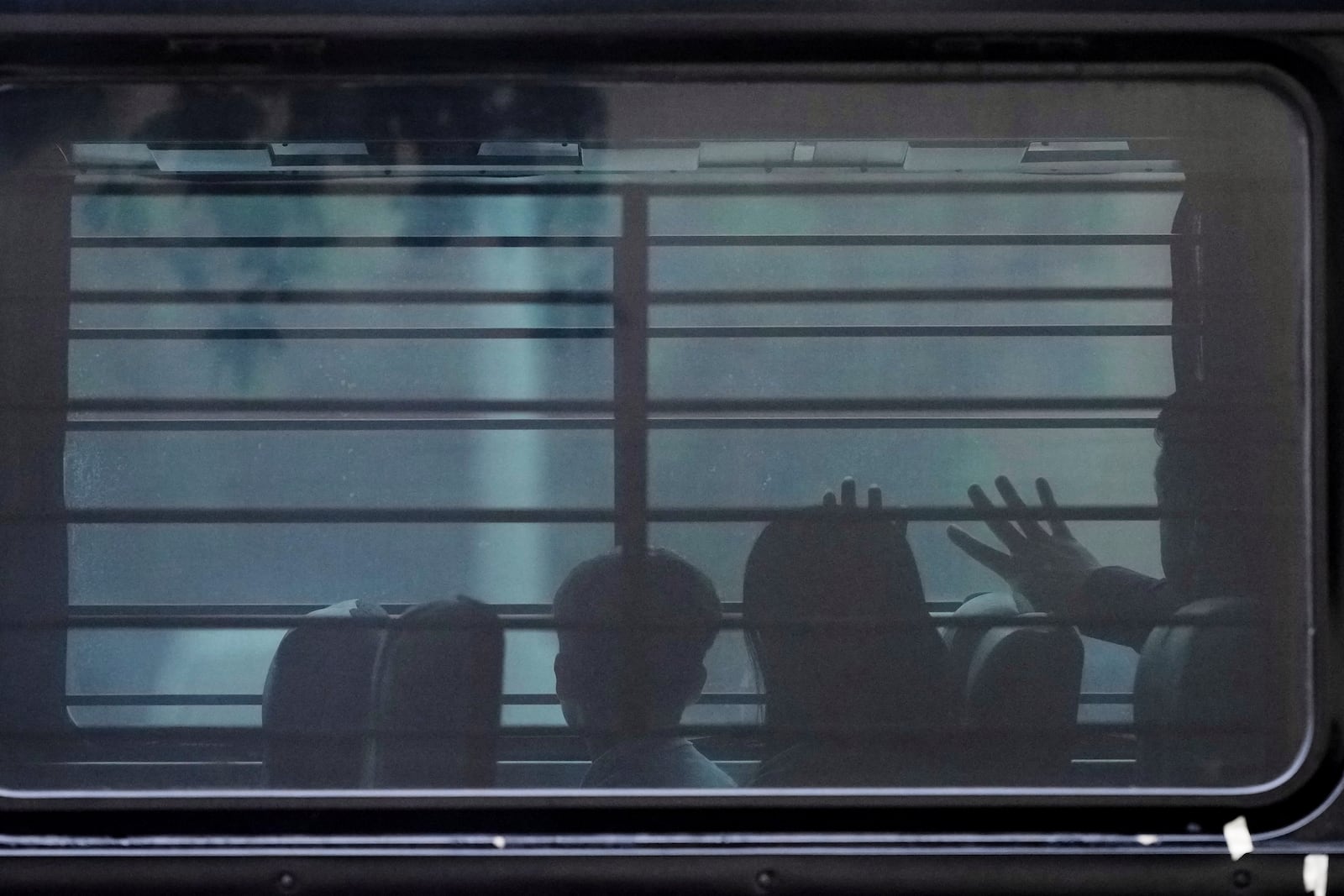 FILE - A family from Cuba is detained and loaded onto a bus with tinted windows and bars following an appearance at immigration court, June 11, 2025, in San Antonio. (AP Photo/Eric Gay, File)