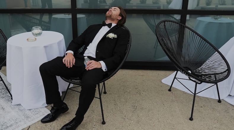 FILE - A Groomsman takes a break after finishing bridal party photos at a wedding on Saturday, Aug. 23, 2025, in Newtown, Ohio. (AP Photo/Joshua A. Bickel, File)