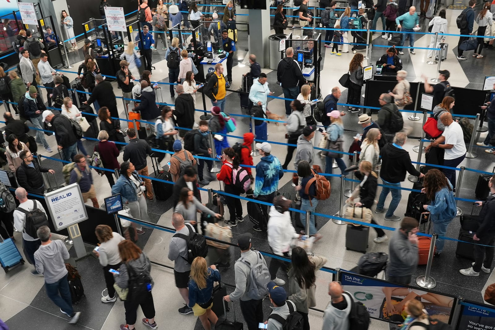 Dozens of travelers wait to go through security check point at O'Hare International Airport in Chicago, Friday, May 23, 2025. (AP Photo/Nam Y. Huh)