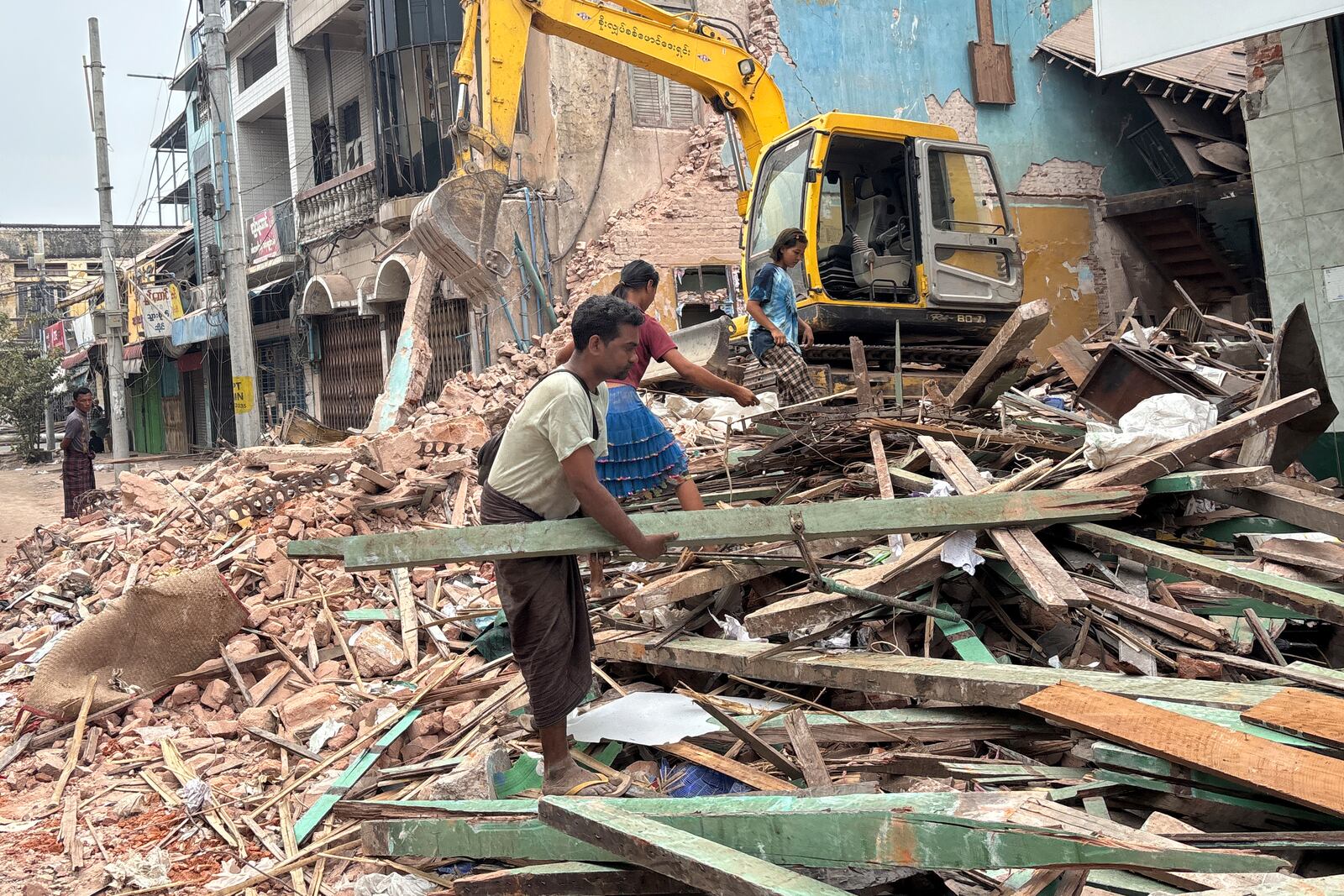 People clean debris from damaged buildings in the aftermath of an earthquake on March 28, in Naypyitaw, Myanmar, Monday, April 7, 2025. (AP Photo)