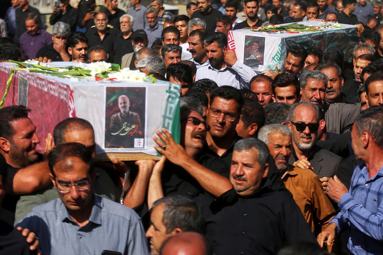 Mourners carry the flag-draped coffins of Ali Hatefi (left) and Abbas Zarei (rright) who were reportedly killed in Israeli strikes during their funeral in the city of Asadabad, Iran, Monday, June 16, 2025. (AP Photo/Abdolrahman Rafati/Tasnim News Agency)