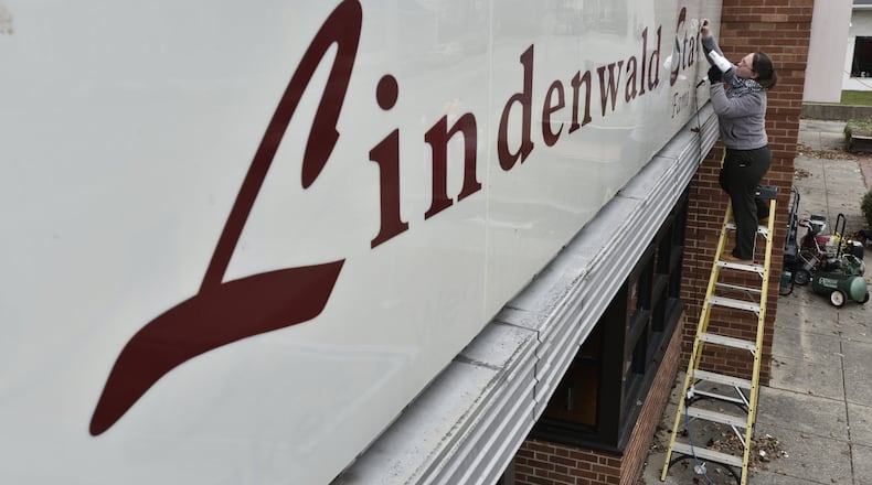 Liz Nash-Pittman removes the lettering from the Lindenwald Station restaurant Wednesday, Dec. 13. The restaurant is moving to a new location at 5072 Pleasant Ave. in Fairfield. NICK GRAHAM/STAFF