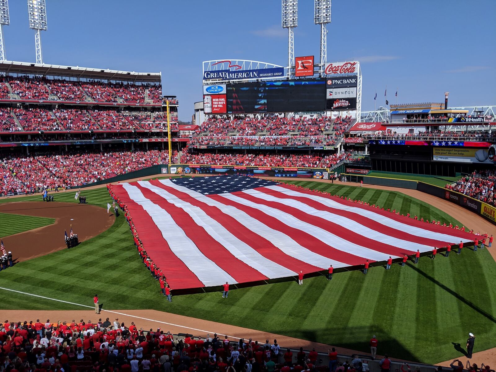 A giant American flag covers Great American Ball Park during the playing of the national anthem before the 2019 Reds Opening Day. SUBMITTED PHOTO