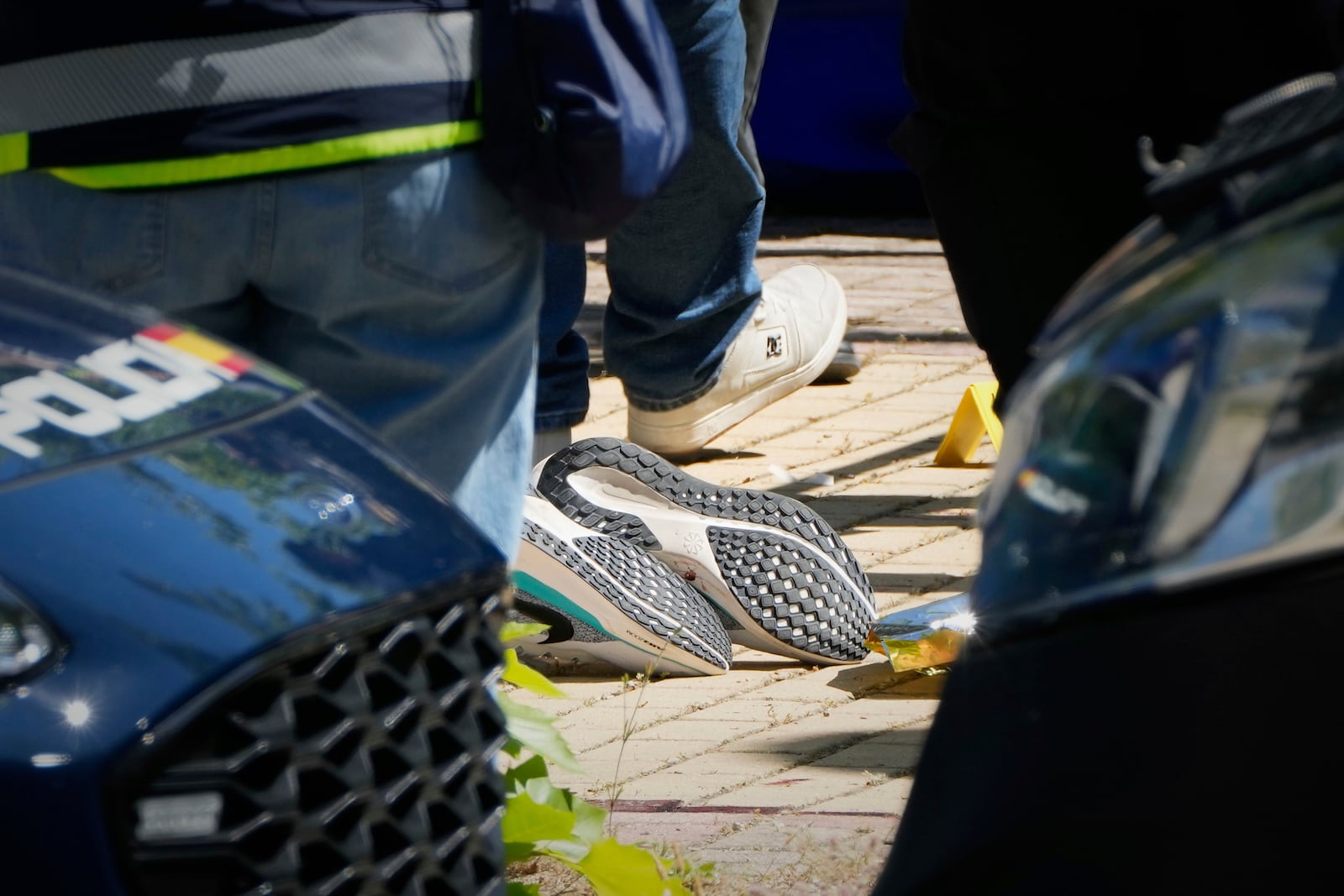 Members of the judicial police work next to the body of an adviser to former Ukrainian president Viktor Yanukovych, at the scene of a shooting, outside a school in Madrid, Spain, Wednesday, May 21, 2025. (AP Photo/Paul White)