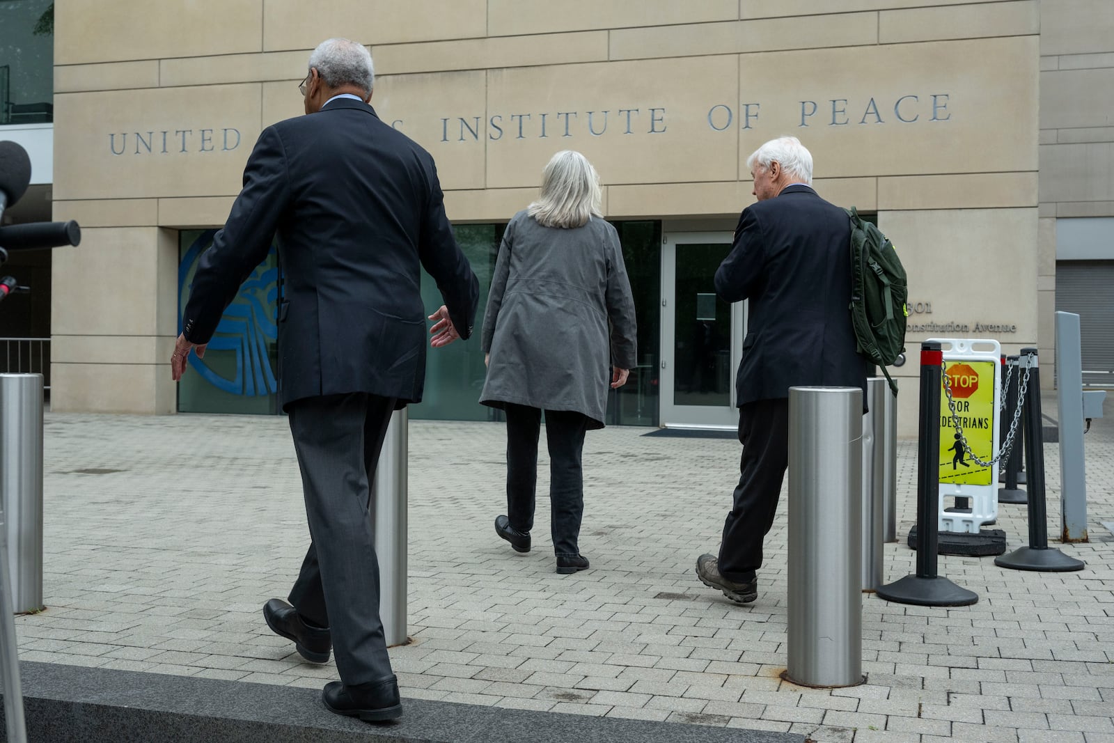 U.S. Institute of Peace (USIP) acting President George Moose, left, and USIP acting counsel George Foote, right, walk back into the Institute following a news conference, Wednesday, May 21, 2025 in Washington. (AP Photo/Kevin Wolf)