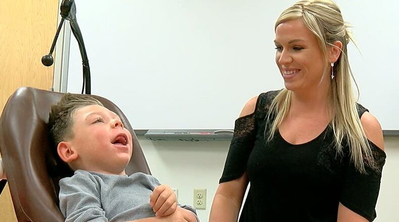 Remington Willman and his mother, Melanie, smile as he enjoys his new mini-car. The car, which was custom-made for him by Lakota East students, is a stylish alternative to a motorized wheelchair and will allow him to play and socialize more easily. WCPO