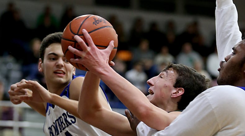 Badin center Jakob Tipton scores between St. Xavier’s David Wassler (44) and Bobby Jefferson during their game at Berning Gymnasium in Springfield Township on Dec. 20, 2016. COX MEDIA FILE PHOTO