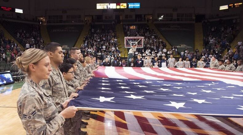 Airmen from Wright-Patterson Air Force Base hold a large American flag during a pregame ceremony prior to a Wright State University basketball game at the Nutter Center. The college hosted a military appreciation night. (U.S. Air Force photo/R.J. Oriez)