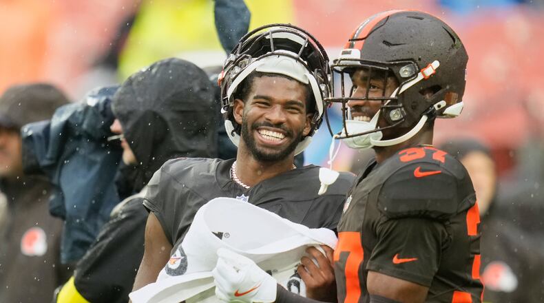 Cleveland Browns quarterback Shedeur Sanders, left, and cornerback Dom Jones, right, talk before an NFL football game against the Miami Dolphins in Cleveland, Sunday, Oct. 19, 2025. (AP Photo/Sue Ogrocki)