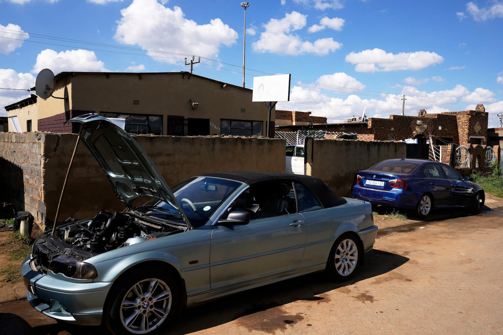 Cars to be repaired are parked outside the workshop of Themba Maseko, a 39-year-old mechanic, in Brakpan, east of Johannesburg, South Africa, Wednesday, April 30, 2025. (AP Photo/Themba Hadebe)