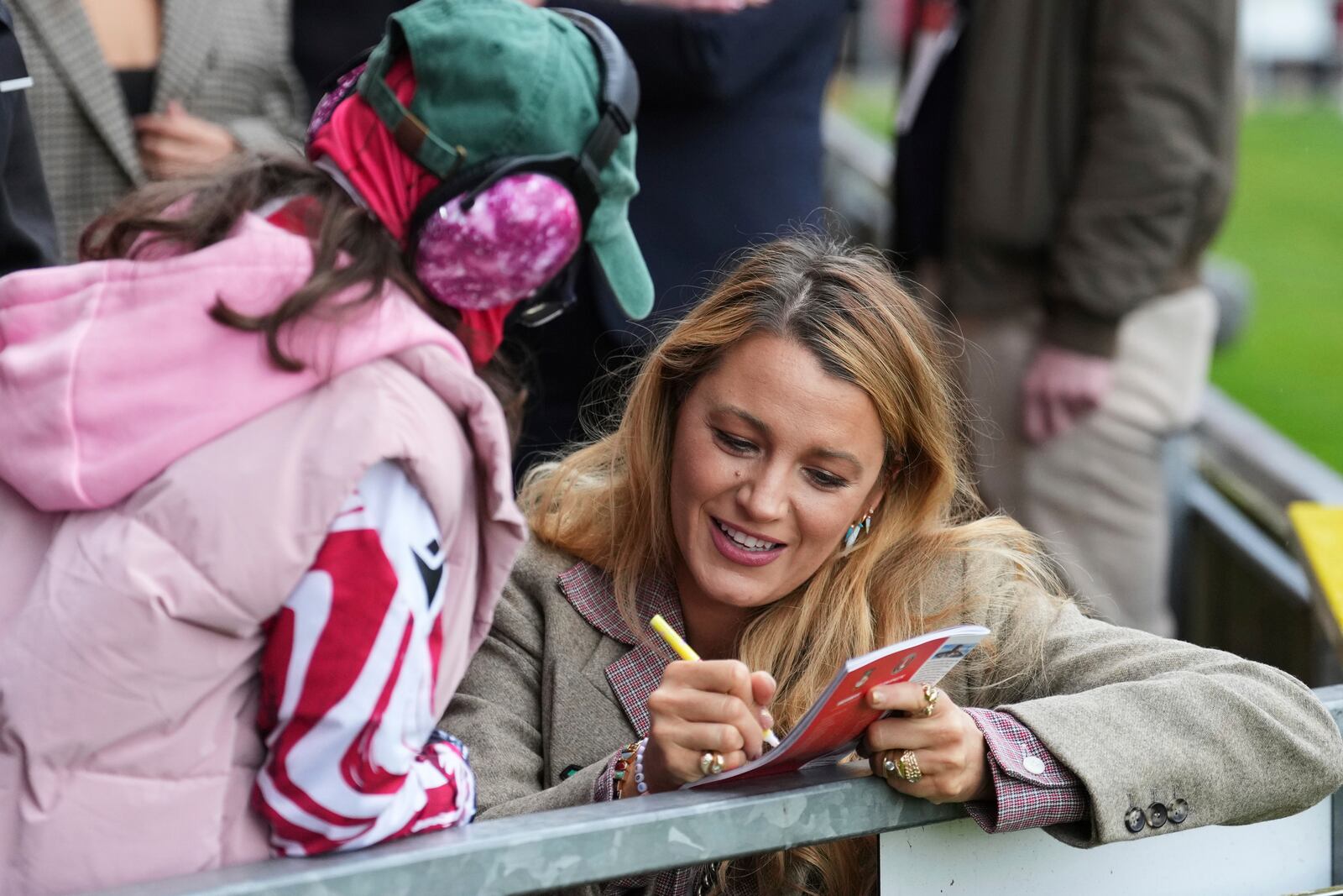 Wrexham co-owners Ryan Reynolds' wife Blake Lively, right, gives autographs to fans before the English League One soccer match between Wrexham and Charlton Athletic at the Racecourse ground in Wrexham, Wales, Saturday, April 26, 2025. (AP Photo/Jon Super)