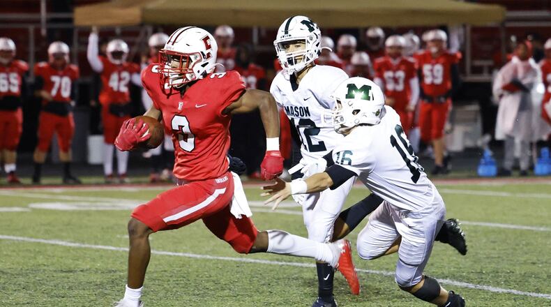 Fairfield's Jordan Jackson runs away from two Mason defenders in their Division I, Region 4 playoff game at Fairfield Stadium on Friday, Oct. 29, 2021. Nick Graham/STAFF