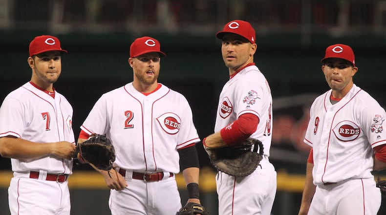 Reds infielders Eugenio Suarez, Zack Cozart, Joey Votto and Jose Peraza talk during a review during a game against the Cardinals on April 20, 2017, at Great American Ball Park in Cincinnati. David Jablonski/Staff