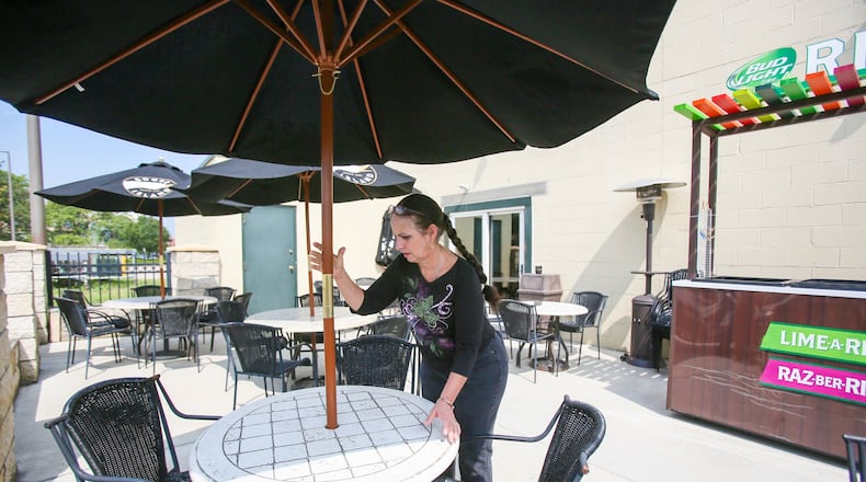 Owner Linda Moorman sets up one of the patio tables on Thursday at Murphy’s Landing in Middletown. A pair of state bills could allow owners of restaurants to permit people to bring their pets as they dine outdoors. GREG LYNCH/STAFF