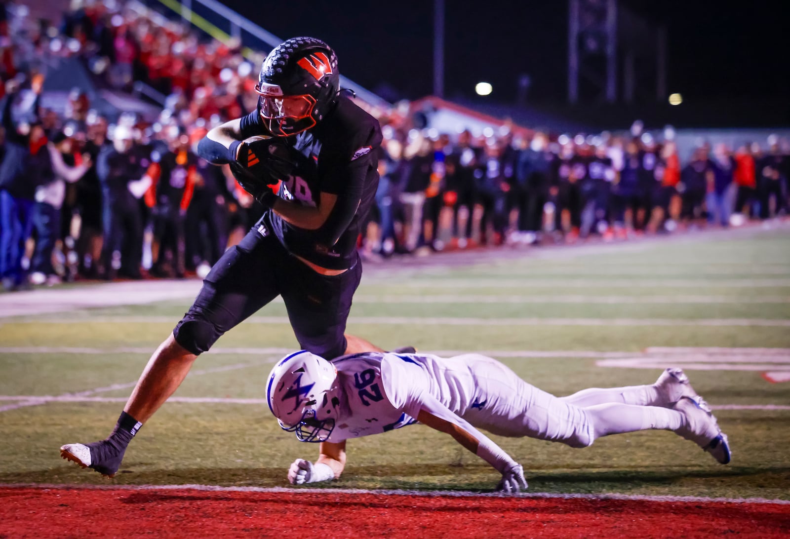 Lakota West's Luka Gilbert runs in for a touchdown defended by St. Xavier's Jax Hendon during their Division 1 playoff football game Friday, Nov. 15, 2024 at Princeton's Mancuso Field in Sharonville. St. Xavier won 16-13 to advance. NICK GRAHAM/STAFF