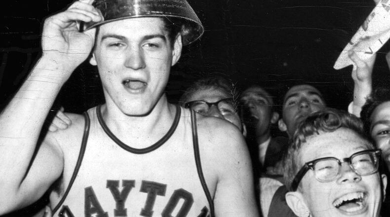 Bill Chmielewski, who led the University of Dayton to a 73-67 victory over St. John's in the finals of the National Invitation Basketball Tournament in 1962, is mobbed by delirious fans at the end of the game. On his head is the trophy he received as the most valuable player. UPI TELEPHOTO